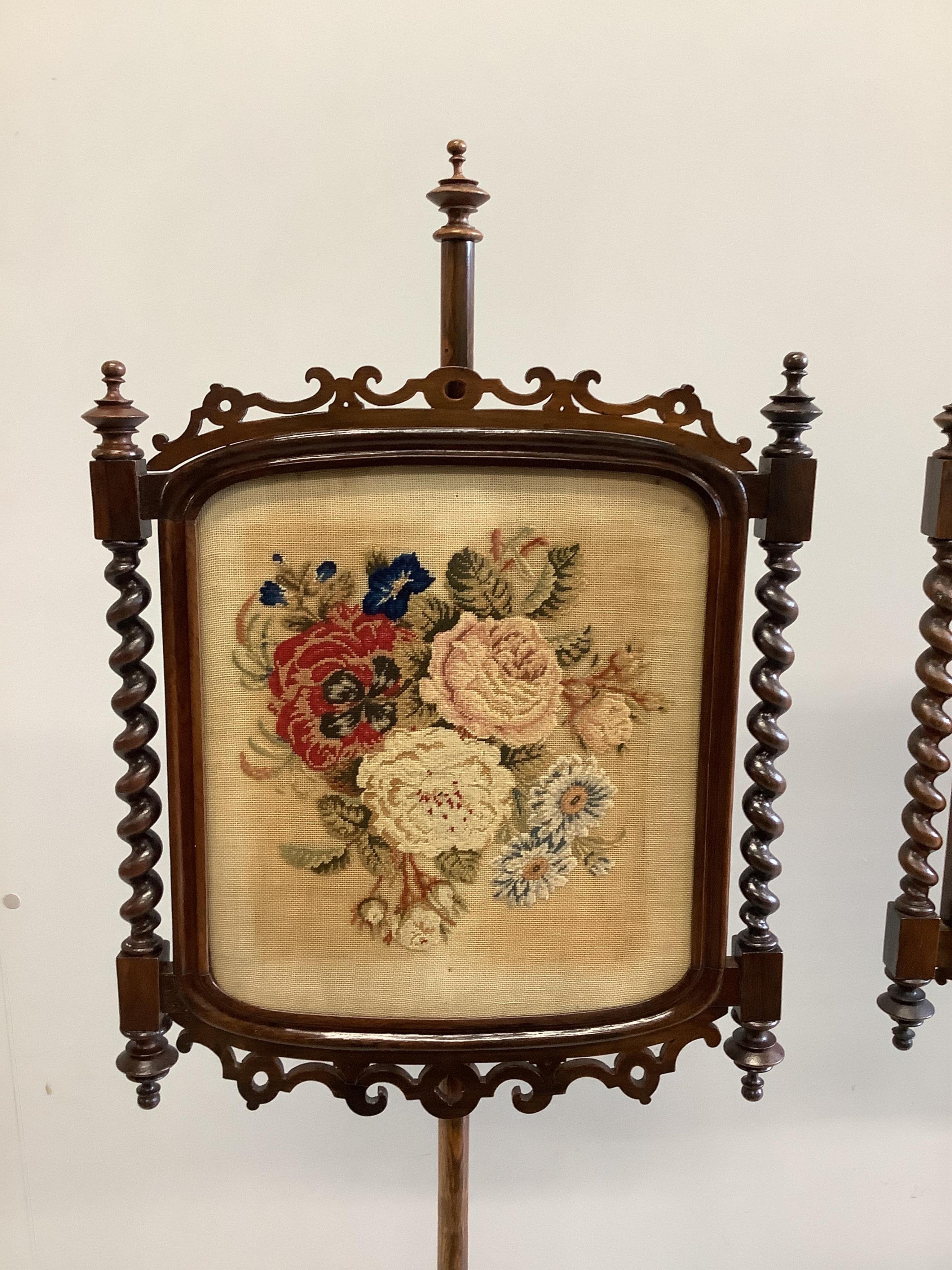 A pair of Victorian rosewood pole screens with floral tapestry banners, height 150cm. Condition - fair